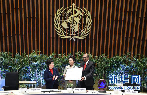 1月18日，国家主席习近平夫人、世界卫生组织结核病和艾滋病防治亲善大使彭丽媛应世界卫生组织总干事陈冯富珍和联合国艾滋病规划署执行主任西迪贝邀请，在瑞士日内瓦出席为她举行的亲善大使任期续延暨颁奖仪式。这是联合国艾滋病规划署执行主任西迪贝向彭丽媛颁发艾滋病防治“杰出成就奖”获奖证书。新华社记者谢环驰摄