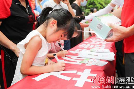 社区居民在活动条幅上签名